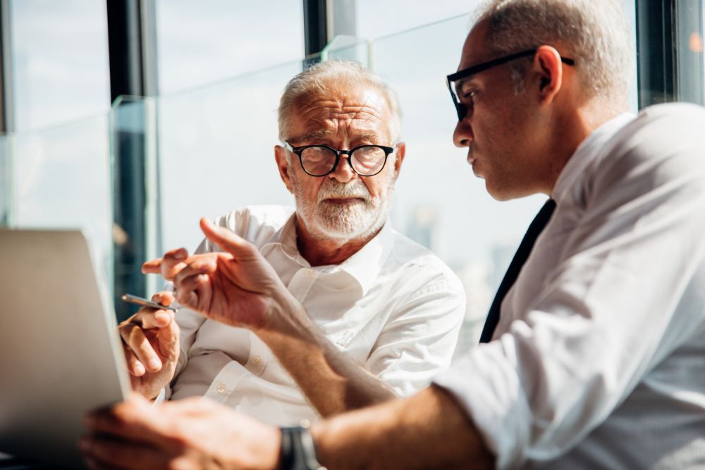 Senior business man talking to a man, a close up
