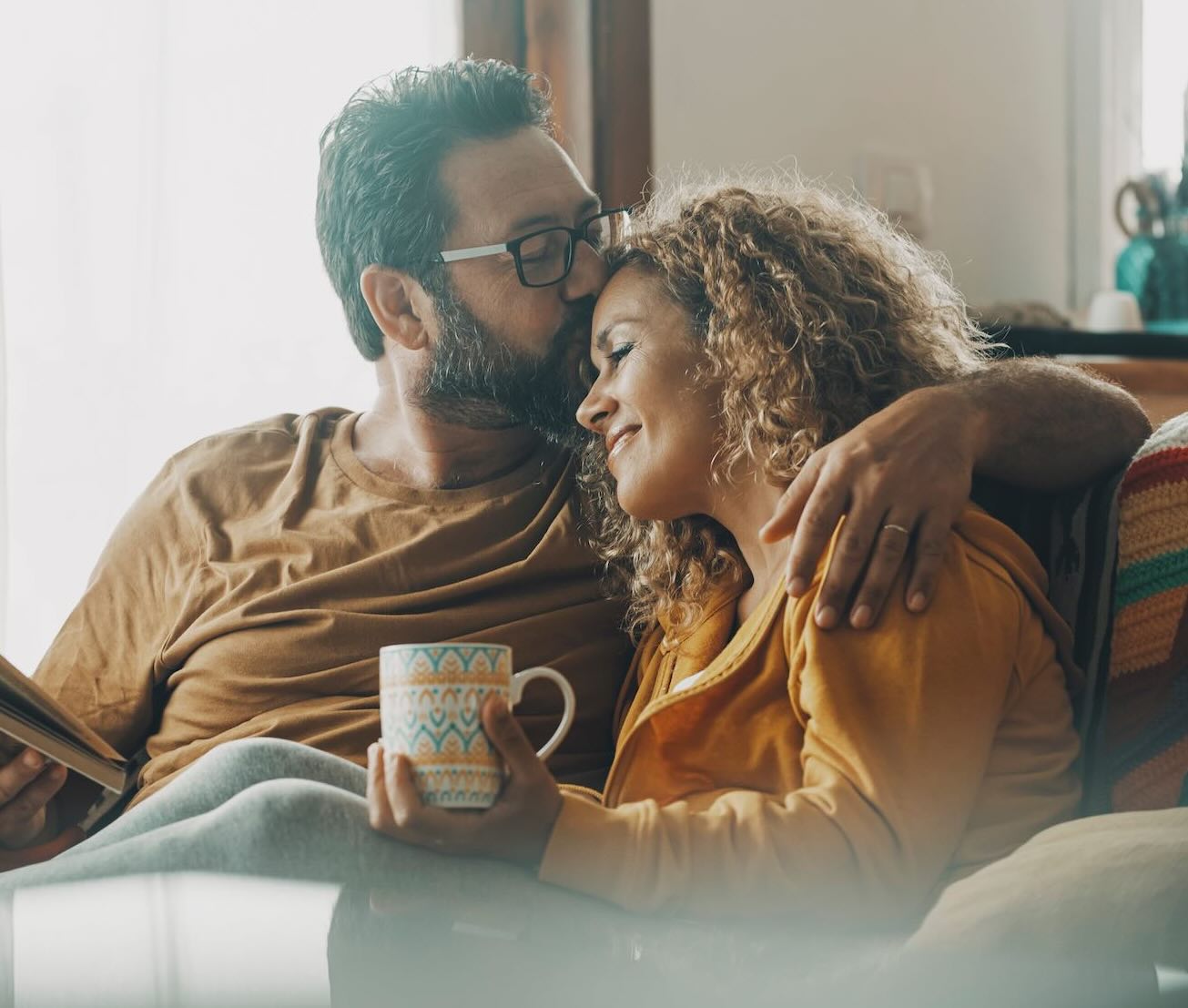 Couple sitting on a couch hugging and relaxing 